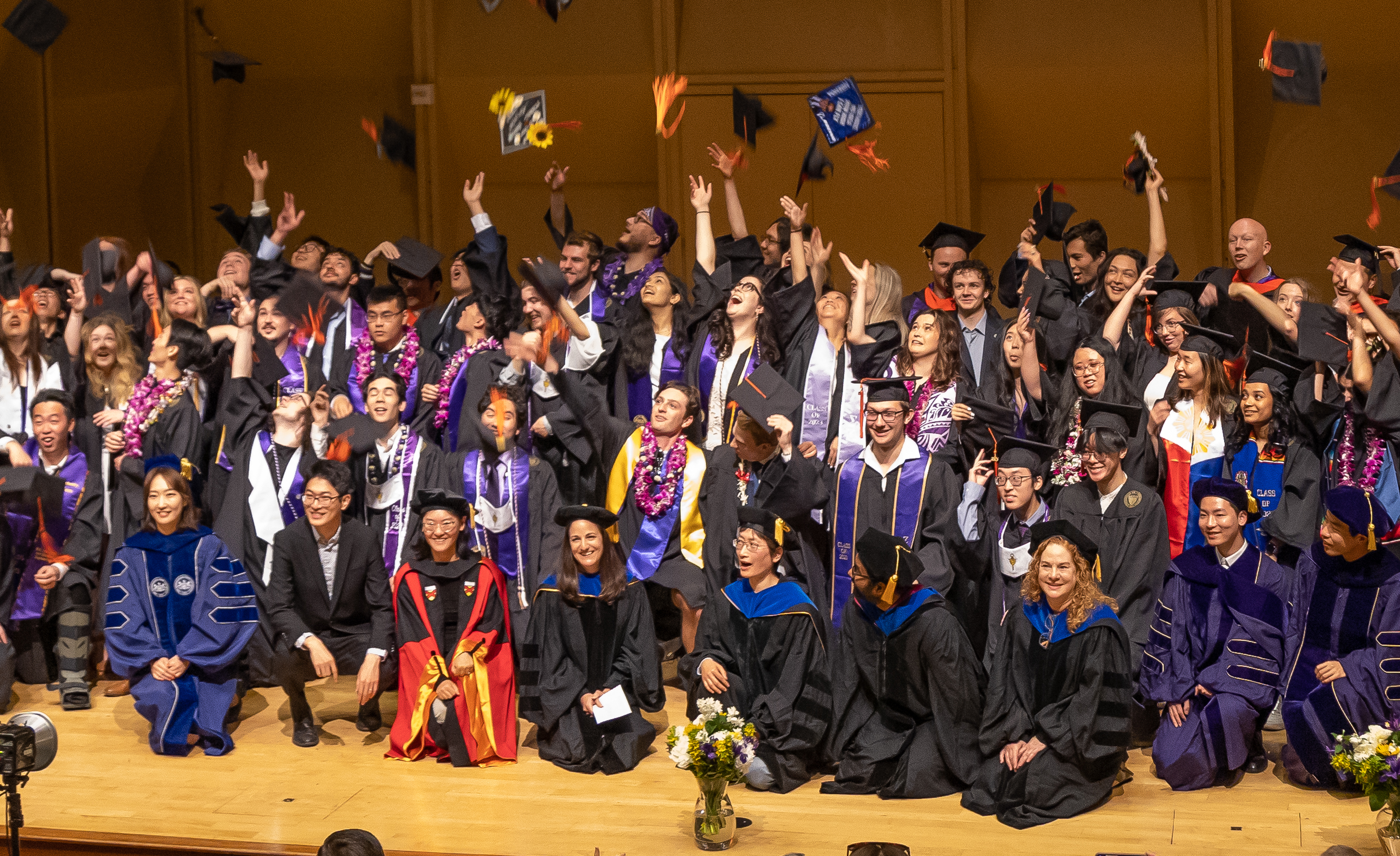 the class of 2023 toss their caps at graduation