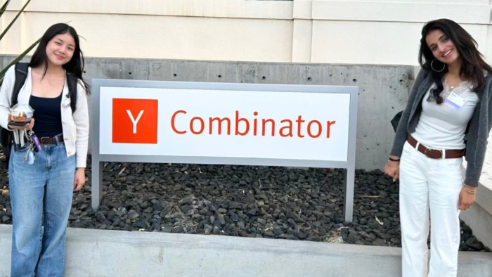 Noelle and Meera flanking the Y Combinator sign