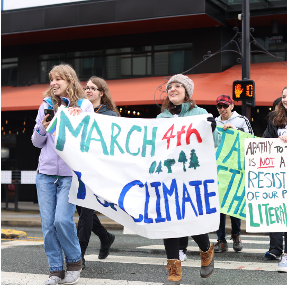 Tchervenski carrying a sign that says 'March 4 Climate' in a parade with a group of students.
