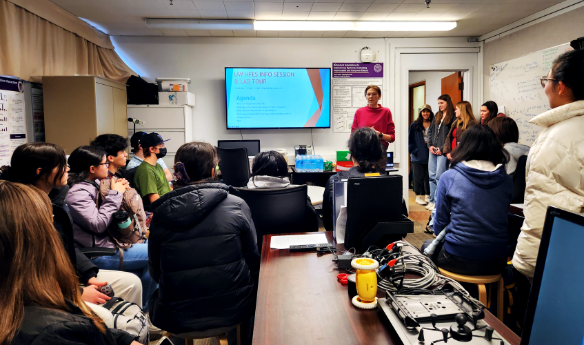 A UW HFES officers speaks to a large groupd of students in the Human Factors and Statistical Modeling Lab.