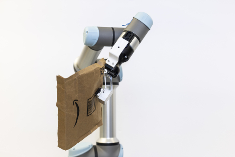 a robotic arm holds an amazon package